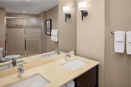 uma casa de banho com 2 lavatórios e um espelho grande em The Limited Hotel em Charleston
