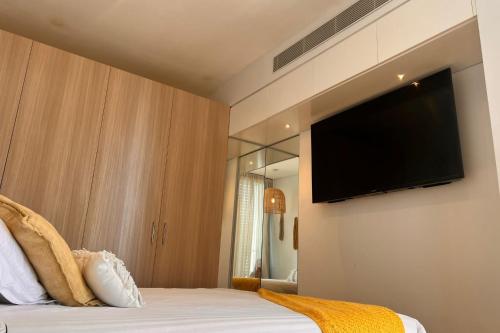 a bedroom with a bed with a flat screen tv on the wall at Stay and Sea! in Sydney