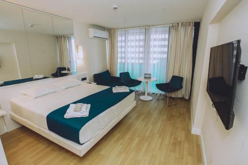 a hotel room with a bed and a mirror at Orbi City Batumi With Sea View in Batumi