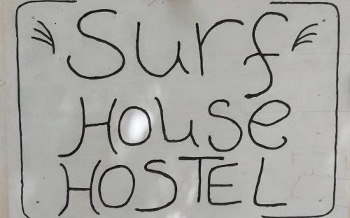 a sign that says slow house house at Surf House Hostel in Santa Maria