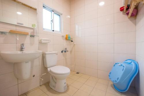 安平的住宿－躲貓貓親子包棟民宿，白色的浴室设有卫生间和水槽。