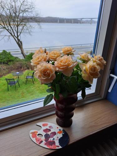 a vase of yellow roses sitting on a window sill at Casa Mundo Bed & Breakfast in Vejle