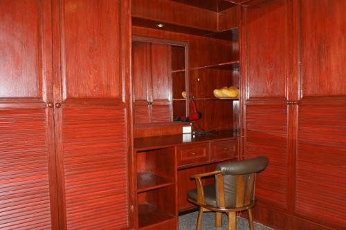 a wooden room with a chair and a desk at Prince Edouard Apartments & Resort Patong Beach Phuket in Patong Beach