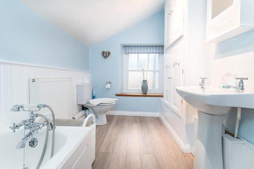 a bathroom with a sink and a tub and a toilet at Rhos Cottage in Conwy