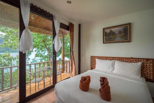 Un dormitorio con una cama y un balcón. en Phi Phi Cozy Seafront Resort, en Islas Phi Phi