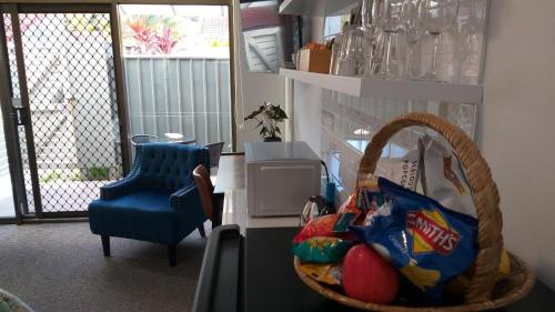 a room with a basket with eggs and a blue chair at Private Suite Nautilus Beach Front Resort in Coffs Harbour