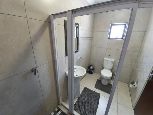 a small bathroom with a toilet and a shower at Khayalami Hotel - Standerton in Standerton