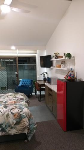 a bedroom with a bed and a desk in a room at Private Suite Nautilus Beach Front Resort in Coffs Harbour