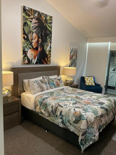 1 dormitorio con 1 cama y una pintura en la pared en Private Suite Nautilus Beach Front Resort en Coffs Harbour
