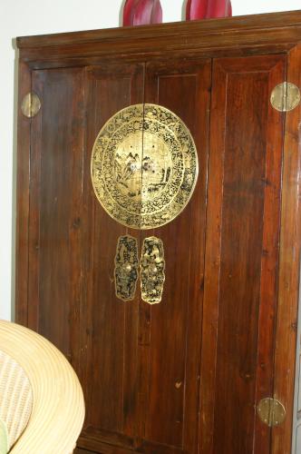 a wooden cabinet with two plates on it at Prince Edouard Apartments & Resort Patong Beach Phuket in Patong Beach