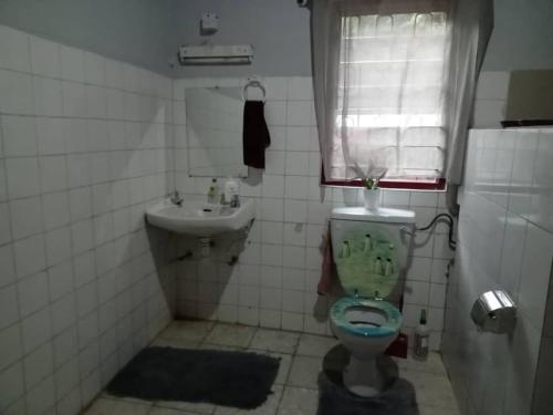 a bathroom with a toilet and a sink at Fajara Suites, Bakau, Banjul, Gambia in Banjul