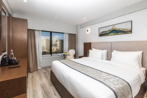 a hotel room with a large bed and a window at Ramee International Surat in Surat
