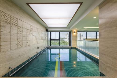 an indoor swimming pool with a large skylight at Ramee International Surat in Surat