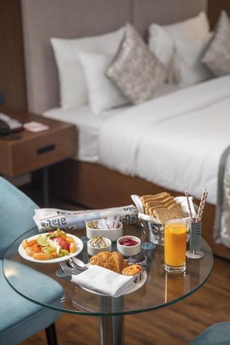 a glass table with a tray of food on top at Ramee International Surat in Surat