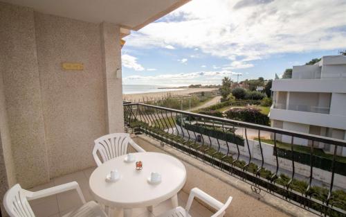 balcón con mesa y sillas y vistas a la playa en Primera línea Playa Cargador - Playamar 1122 - ALBERT VILLAS, en Alcossebre