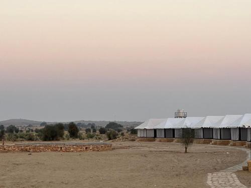 a large building with white roofs in a field at Golden villa in Jaisalmer