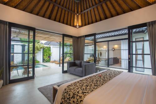 - une chambre avec un grand lit et un canapé dans l'établissement The Kon's Villa Bali Seminyak, à Seminyak