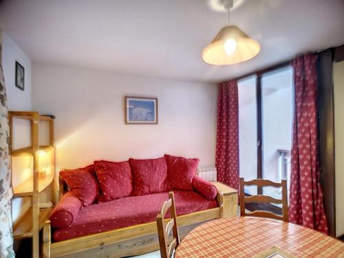 un salon avec un canapé rouge et une table dans l'établissement Les Menuires: 2 Pièces, 4 Pers, Pied des Pistes, Parking Gratuit - FR-1-178-100, aux Menuires