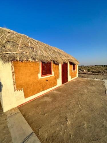 a small building with a thatched roof on the beach at Golden villa in Jaisalmer