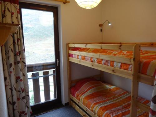 une chambre avec deux lits superposés et une fenêtre dans l'établissement Studio cabine 4 pers, ski aux pieds, Les Menuires, 24m², balcon sud-ouest, proche commerces et remontées. - FR-1-178-101, aux Menuires