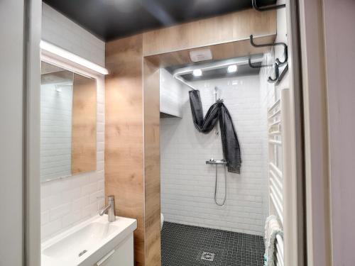 La salle de bains est pourvue d'un lavabo et d'une douche avec une lettre k. dans l'établissement Charmant 2P rénové 4 pers, sud, balcon, ski aux pieds, Les Menuires - FR-1-178-137, aux Menuires