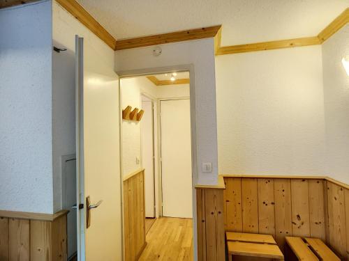 un couloir avec une porte et une pièce avec du parquet dans l'établissement Joli Studio 2 Pers, Wifi, Animaux Admis, Parking - FR-1-178-180, aux Menuires