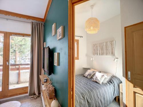 une chambre avec un lit et une télévision sur un mur dans l'établissement Superbe 2 pièces 4 pers, balcon, au pied des pistes, WiFi - FR-1-178-190, aux Menuires