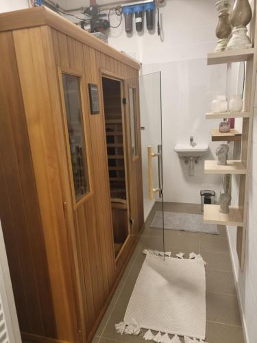 Łazienka z drewnianymi drzwiami i umywalką w obiekcie Vakantiewoning Bisonder w mieście Bilzen