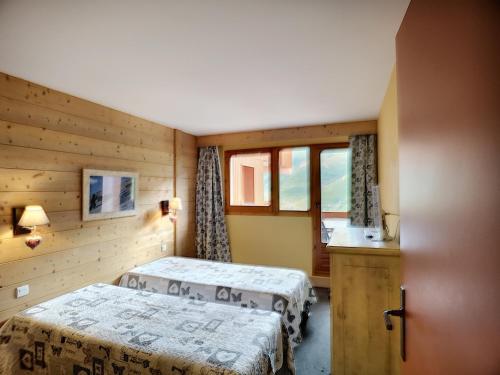 um quarto de hotel com duas camas e uma janela em Appartement Les Menuires, 2 pièces, 5 personnes - FR-1-178-294 em Les Menuires