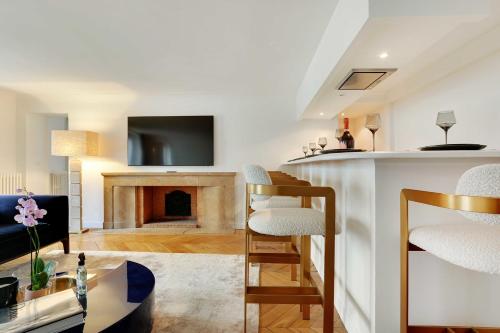 uma sala de estar com lareira e televisão em Amazing apartment 2BR4P avenue Montaigne Triangle d'Or em Paris