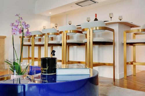 une chambre avec des chaises et une table avec des livres dans l'établissement Elegant apartment - 2BD-6P - Avenue Montaigne, à Paris