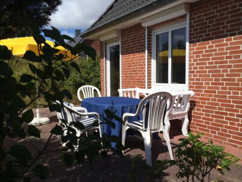 three chairs and a table on a patio at Ferienhaus am Kniep in Wittdün