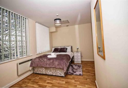 a bedroom with a bed and a large window at Superb Balconied 2Bedroom Flat in Heart of City Centre in Leeds