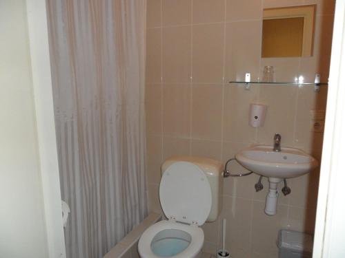 a bathroom with a toilet and a sink at Royal Hotel in Brussels