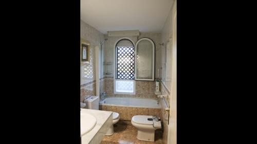 a bathroom with a tub and a sink and a toilet at Apartment 10 minutes walk from Puerto Banus in Marbella