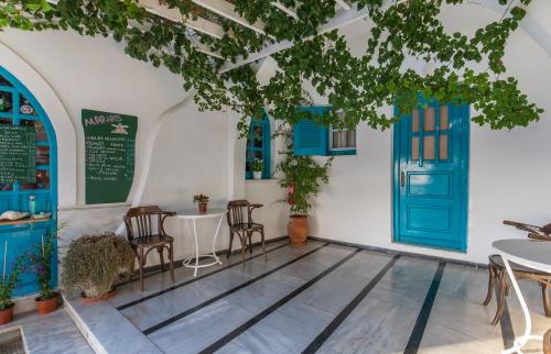 een restaurant met een blauwe deur en tafels en stoelen bij Pension Marias in Mykonos-stad