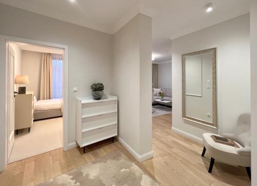 a living room with a mirror and a bedroom at Kurkowa Apartments in Szczecin