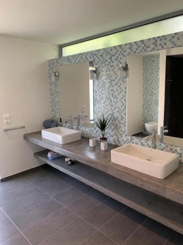 a bathroom with two sinks and a large mirror at Villa Nafsika stunning view on the Aegean Sea in Áyioi Apóstoloi