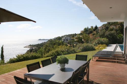 a table with chairs and a potted plant on a patio at Villa Nafsika stunning view on the Aegean Sea in Áyioi Apóstoloi