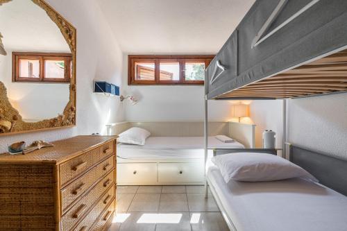 a bedroom with two beds and a mirror at Domus Luna Apartment with sea view Villasimius in Villasimius