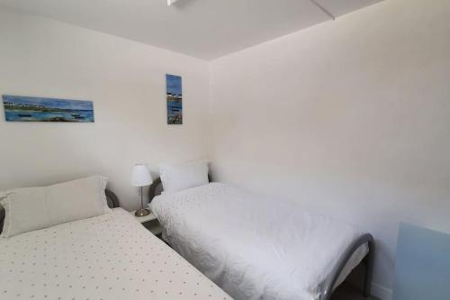 deux lits dans une petite pièce aux murs blancs dans l'établissement Appartement T2 à 500m de la plage et du marché., à Saint-Brévin-les-Pins