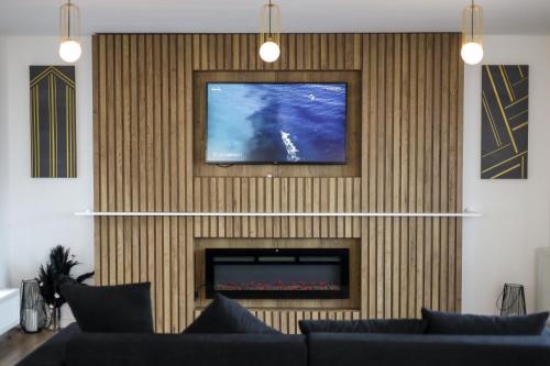 摩爾多瓦地區肯普隆格的住宿－Pensiunea CityView，带沙发的客厅和墙上的电视