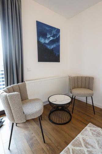 a living room with two chairs and a table at Pensiunea CityView in Câmpulung Moldovenesc
