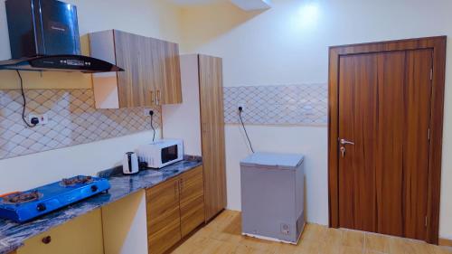 a kitchen with a counter with a microwave and a door at Abuja Shortlet City with 24hr power, Wifi, Fully Secured Environment in Abuja