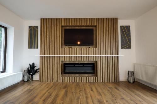 a living room with a fireplace with a flat screen tv at Pensiunea CityView in Câmpulung Moldovenesc