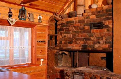 a kitchen with a brick wall and a brick oven at Sodyba Vieversynė in Duokiškis