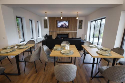 a living room with tables and chairs and a couch at Pensiunea CityView in Câmpulung Moldovenesc