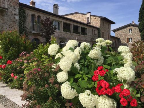 a garden of white and red flowers in front of a building at Appartamento Stella in Pozzolengo