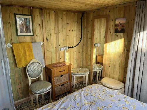 a bedroom with a bed and two chairs and a desk at Hardwick View Lodge in Holmewood