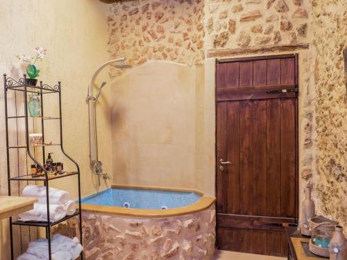 a bathroom with a tub with a wooden door at Villa Malaxa Private Luxury with Amazing View in Maláxa